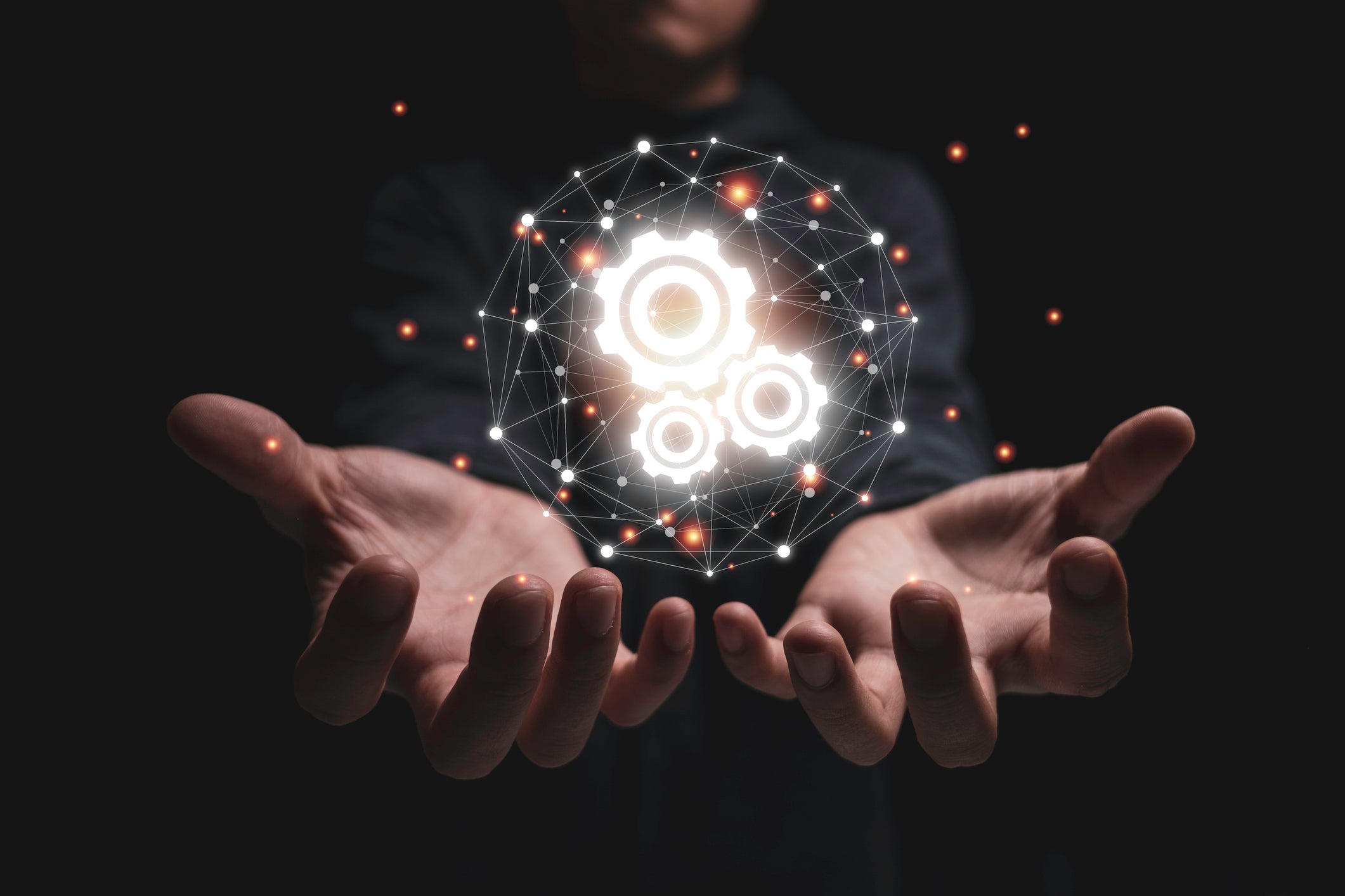 a man holds a geometric ball with a gears symbol in the middle