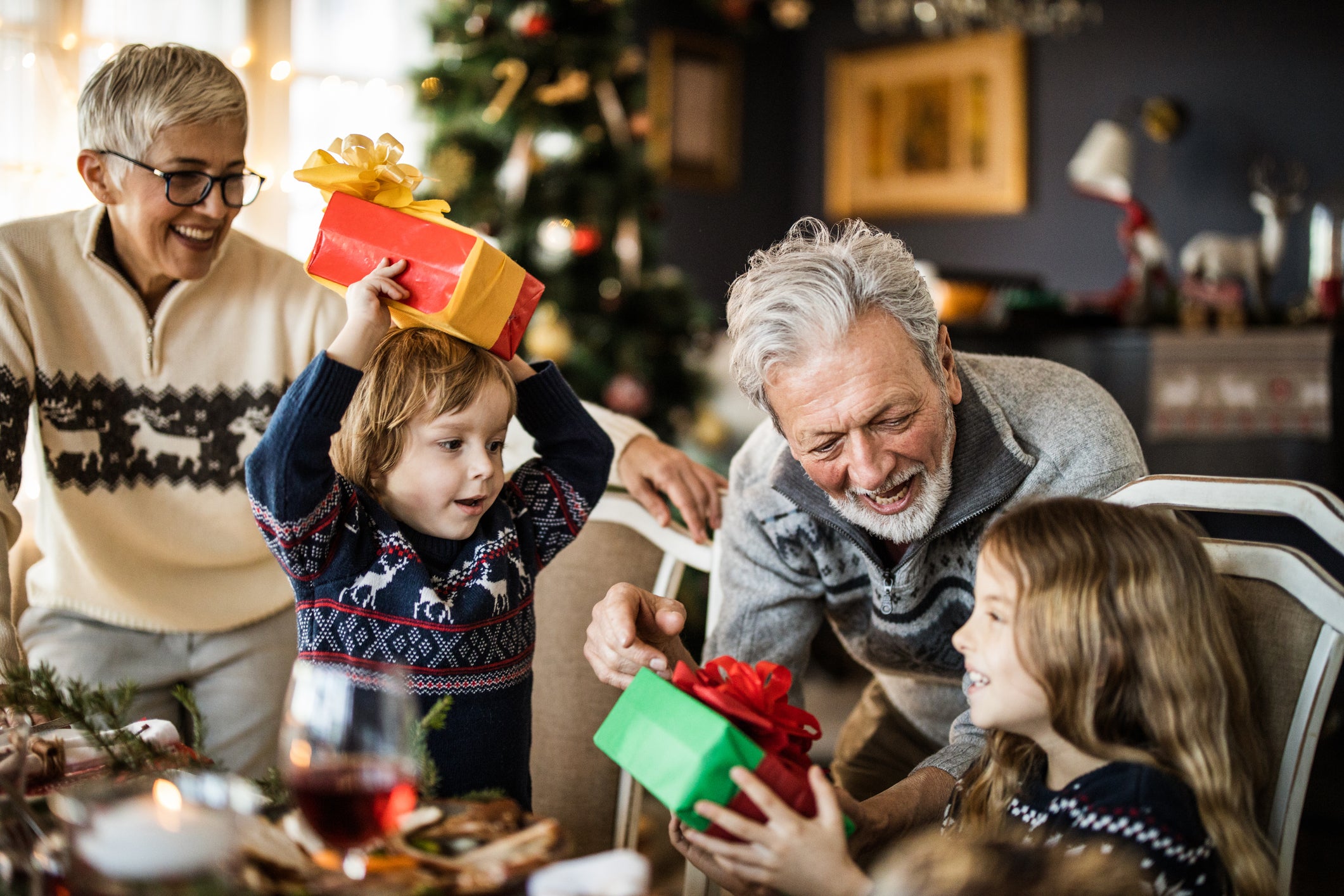 two young children and two grandparents exchange gifts