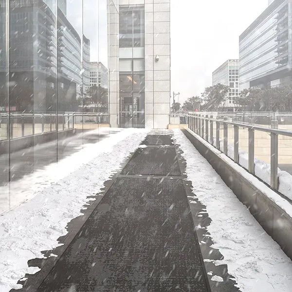 HeatTrak Pro Industrial Walkway Mat with melted snow path in front of commercial property