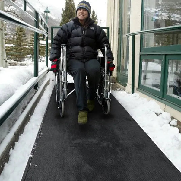man in wheelchair on heattrak mobility ramp mat