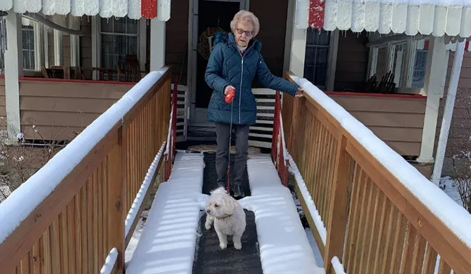 A customer and her dog walking on a HeatTrak Mat at their house.