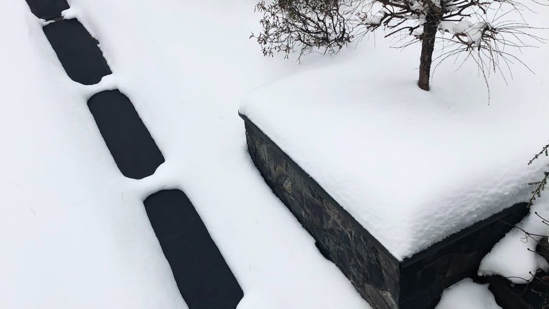 three snow melting mats in black are on a blanket of thick snow