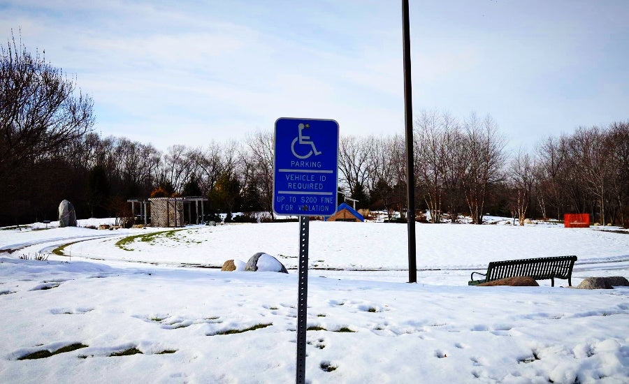 Handicap parking sign in front of snowy landscape