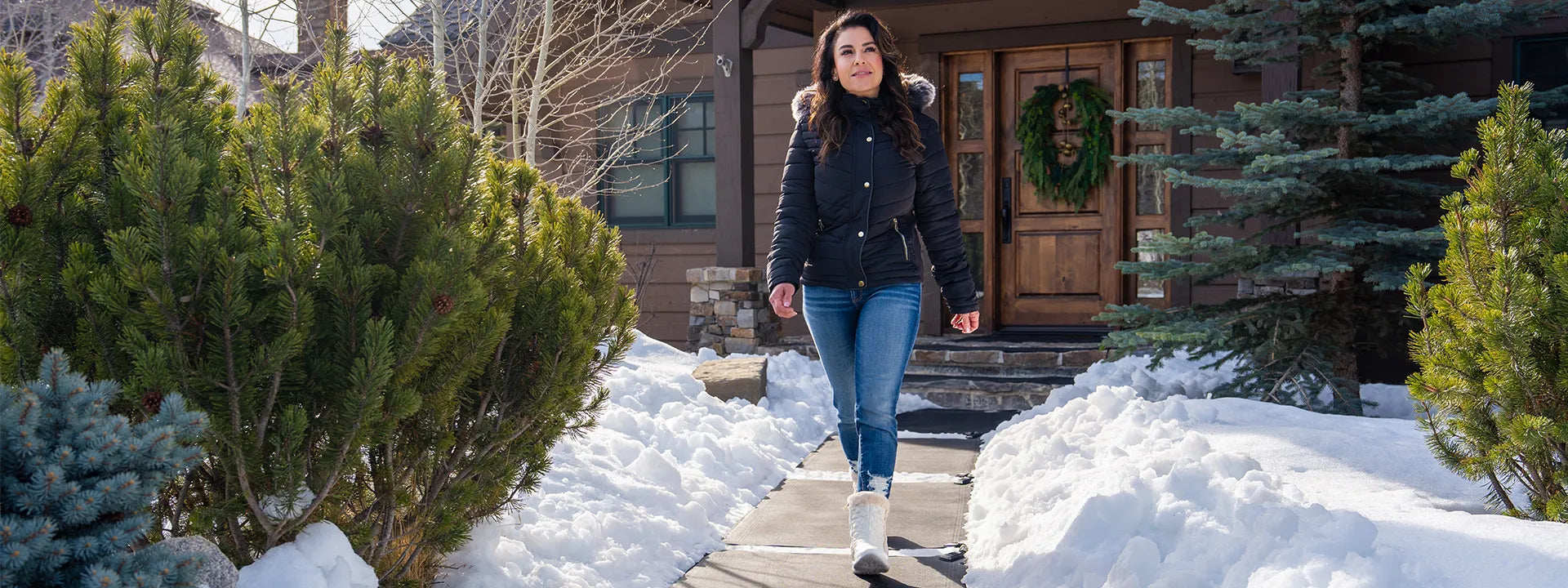A woman walking confidently on her walkway which was cleared by HeatTrak's snow melting mats.